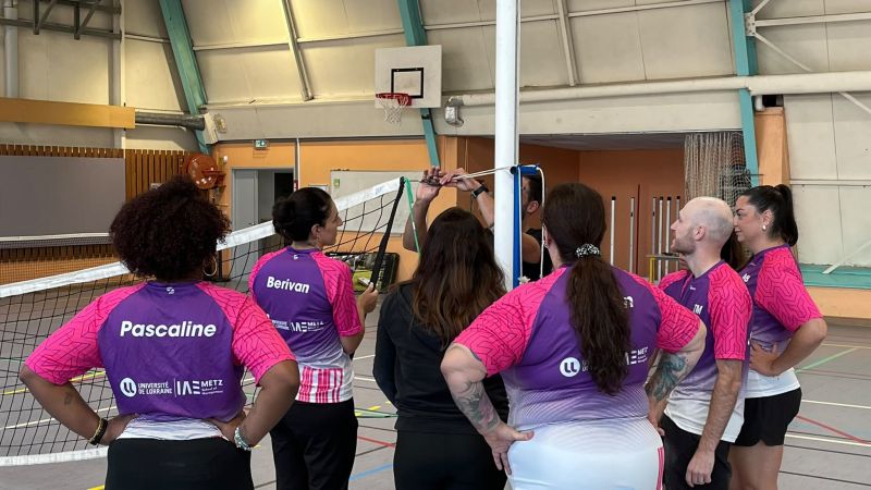 Les équipes apprennent à monter un filet de volley-ball